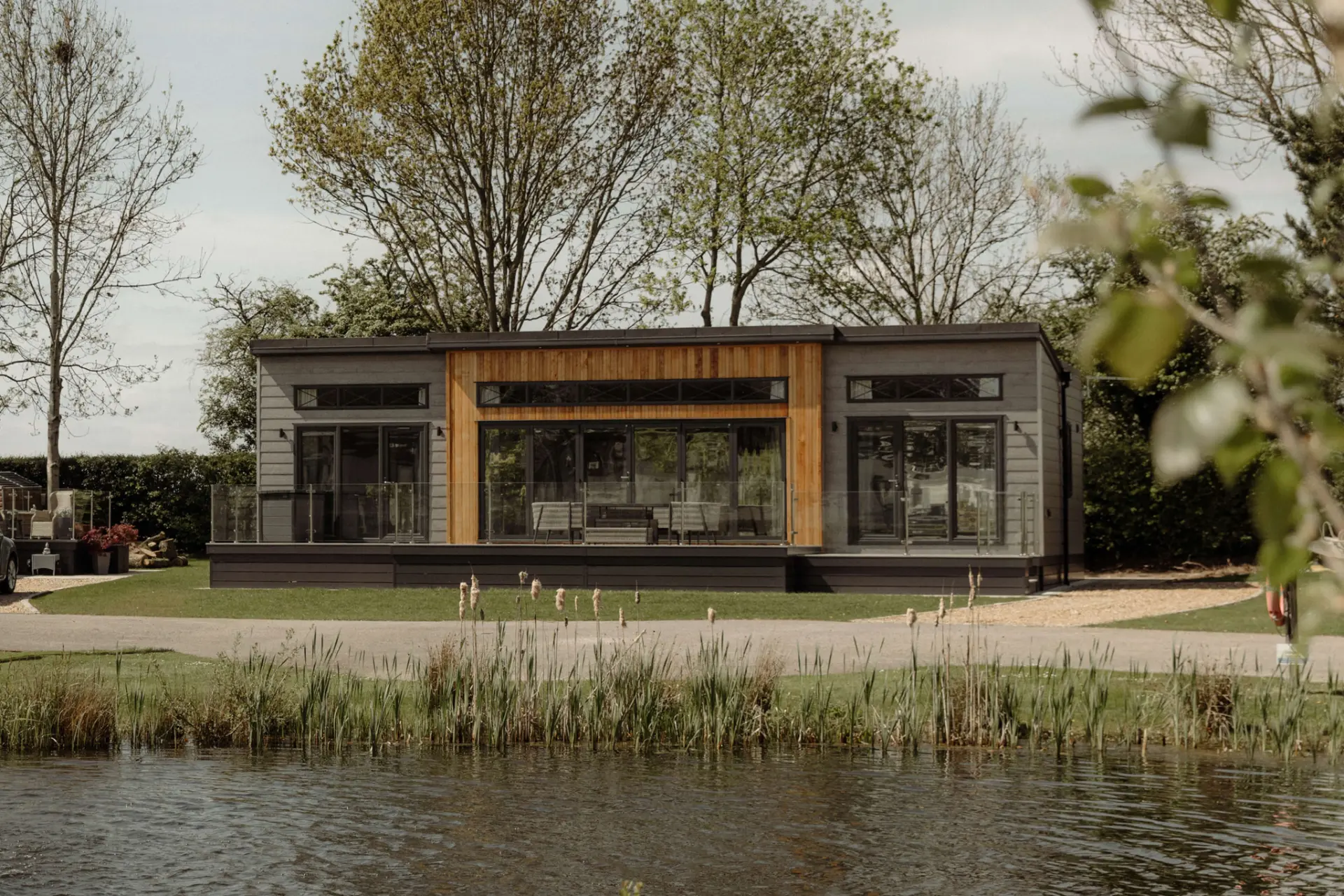 Contemporary twin lodge viewed across the water at Pickmere Lake